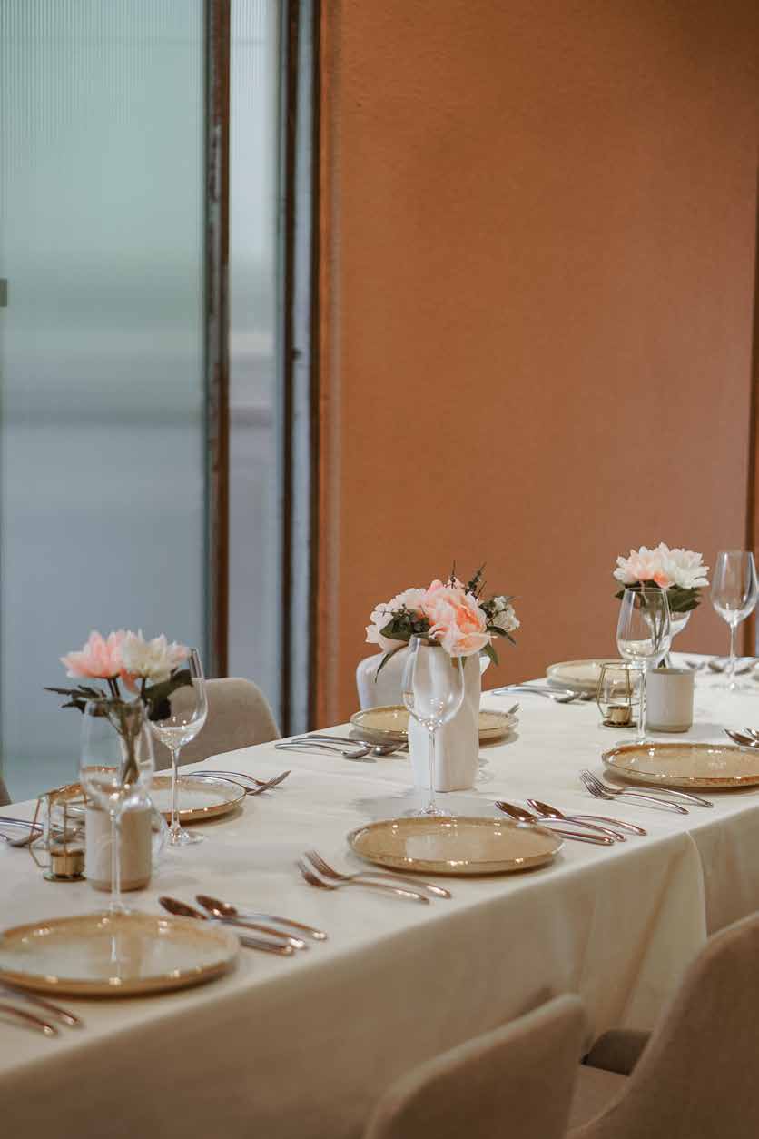 A long table in the VIP Room set with white linen, flowers and glassware for a private dinner